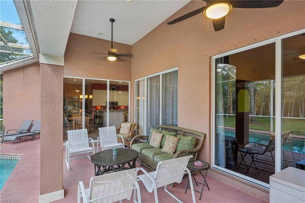 View of patio featuring a ceiling fan, an outdoor pool, glass enclosure, and a sunroom