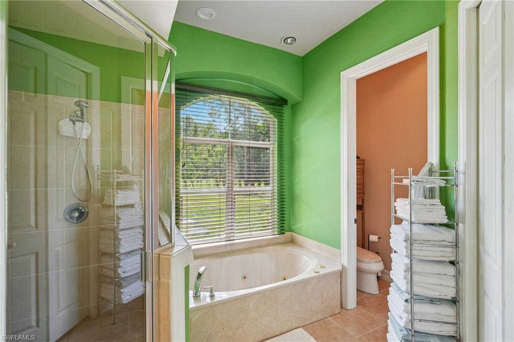 Bathroom featuring a shower stall, a whirlpool tub, and tile patterned flooring