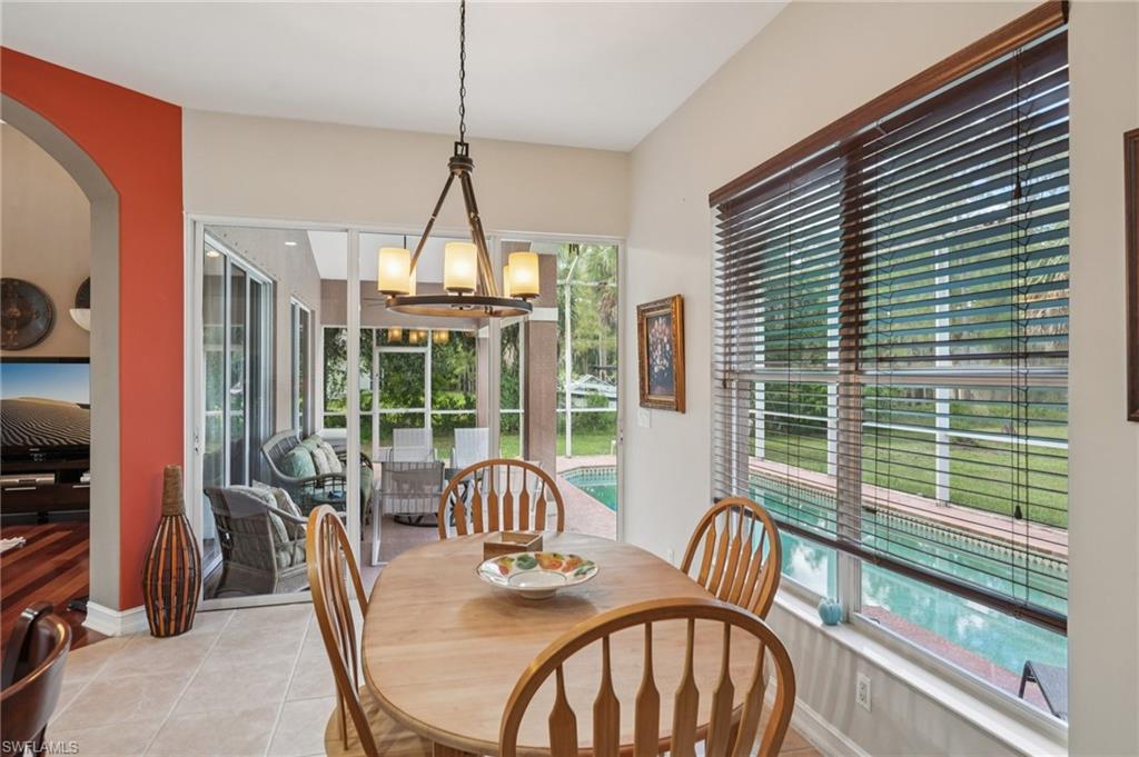 Tiled dining room featuring a chandelier and arched walkways