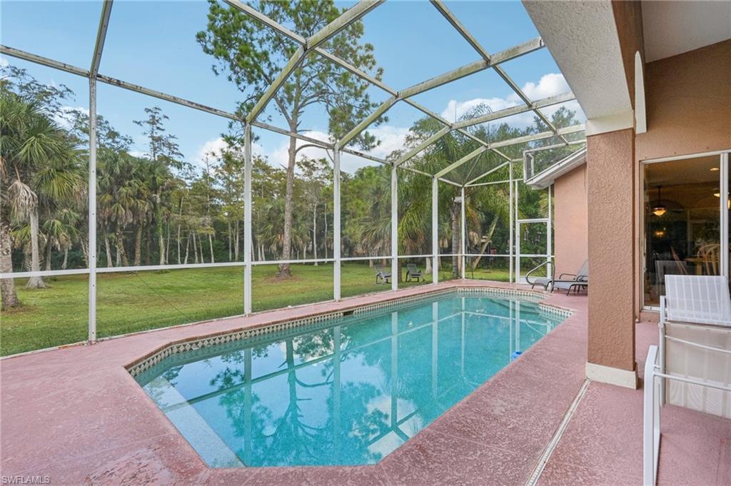 Swimming pool with a sunroom, a patio area, a lanai, and a yard