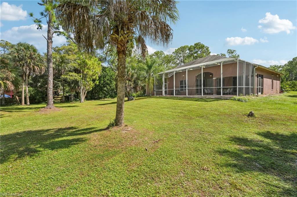 View of green lawn featuring a sunroom