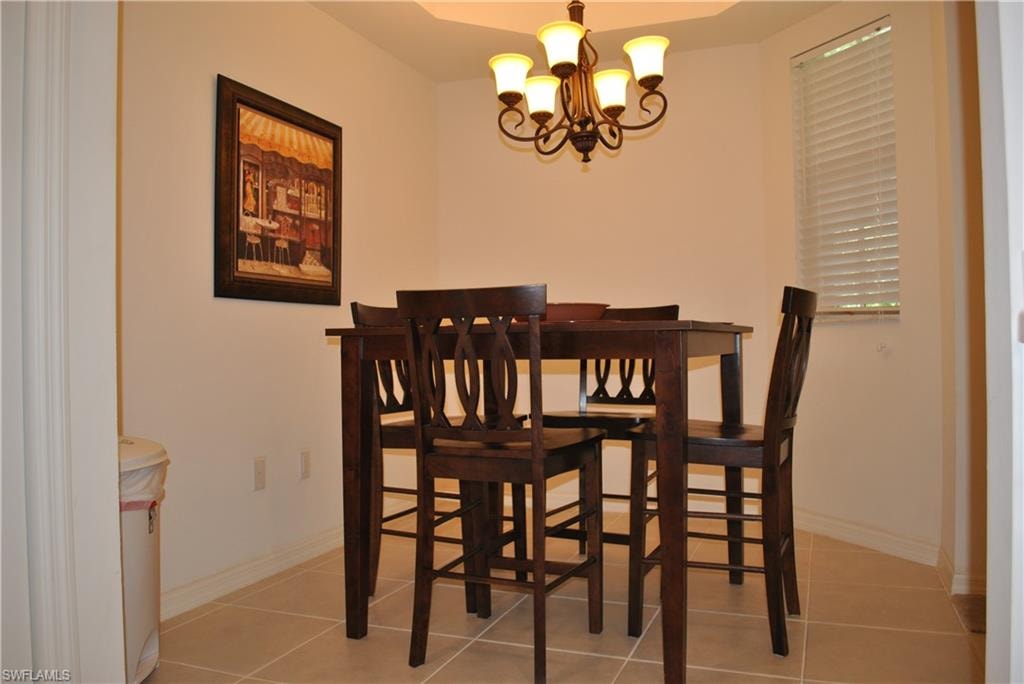 Dining room featuring light tile patterned floors and a chandelier