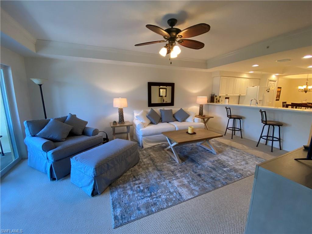 Living area featuring carpet floors, a tray ceiling, crown molding, ceiling fan, and recessed lighting