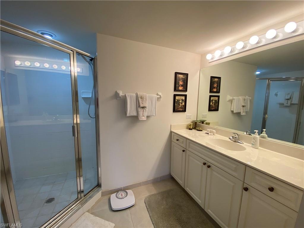 Bathroom with vanity, a stall shower, and light tile patterned floors
