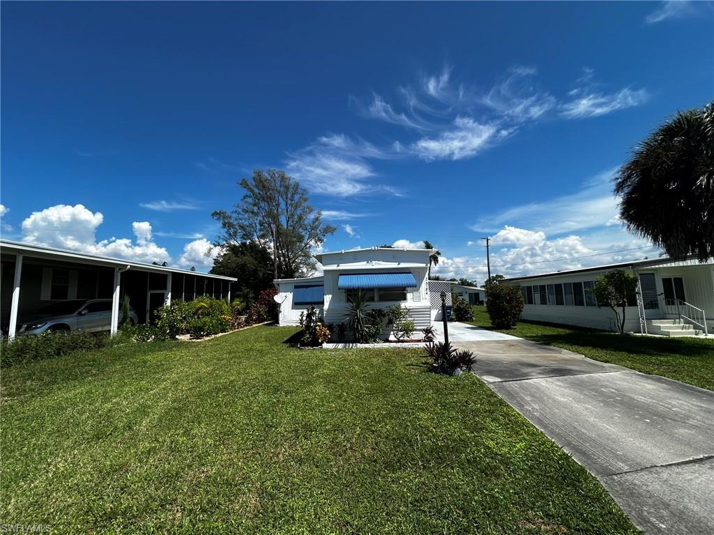 View of green lawn with concrete driveway