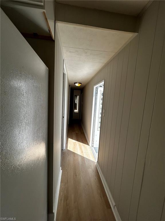 Hall featuring wood finished floors and wooden walls