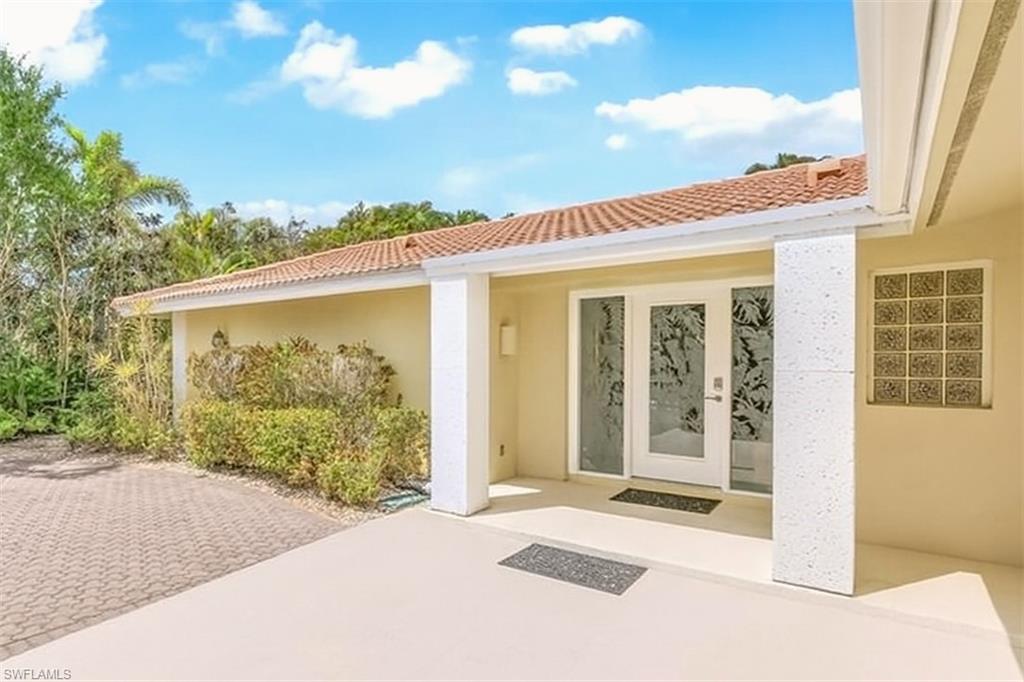 Property entrance with stucco siding and a tile roof