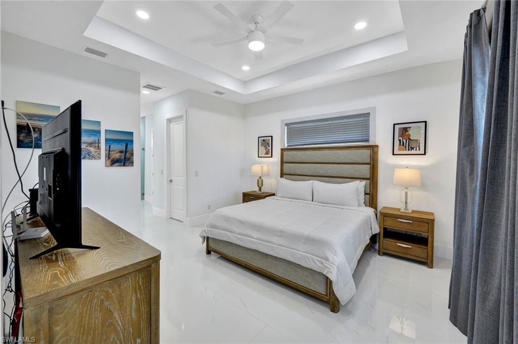 Bedroom featuring a tray ceiling, recessed lighting, and a ceiling fan