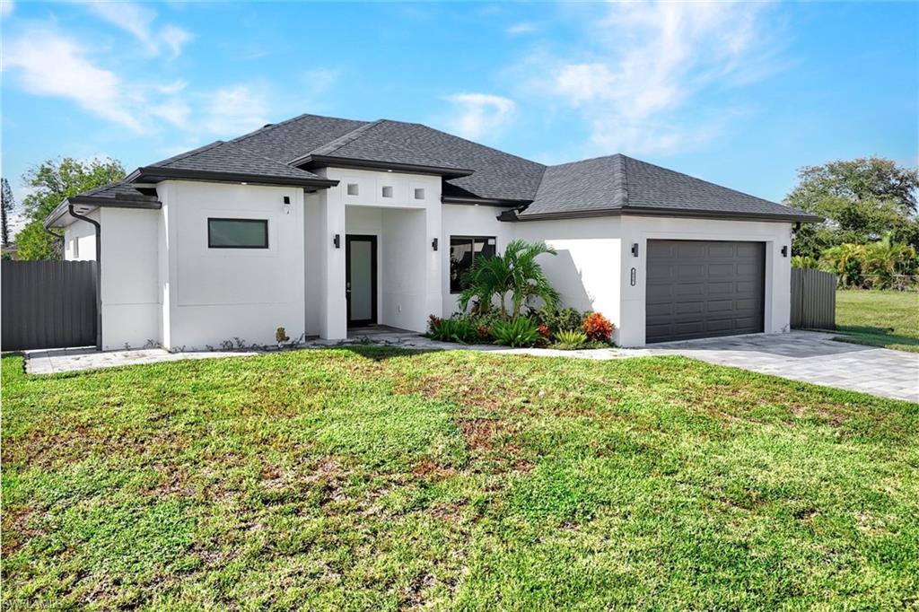 View of front of house featuring an attached garage, stucco siding, decorative driveway, and roof with shingles