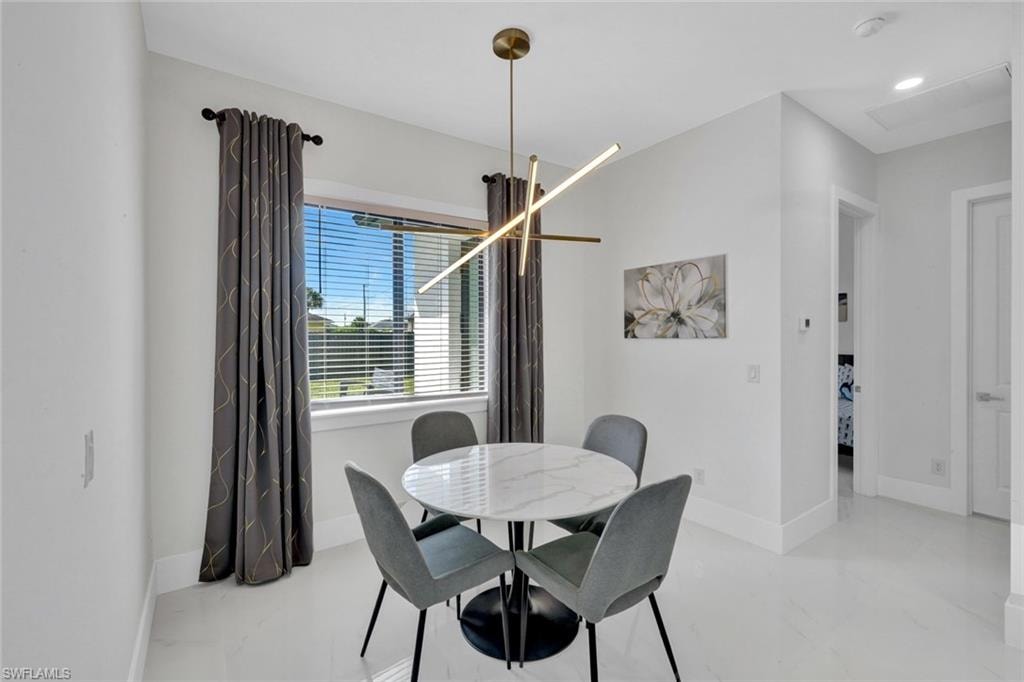 Dining area featuring baseboards and a chandelier
