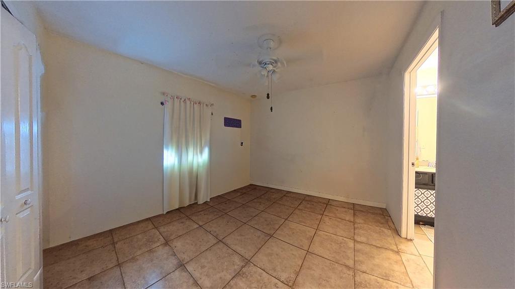 Spare room with a ceiling fan and light tile patterned flooring