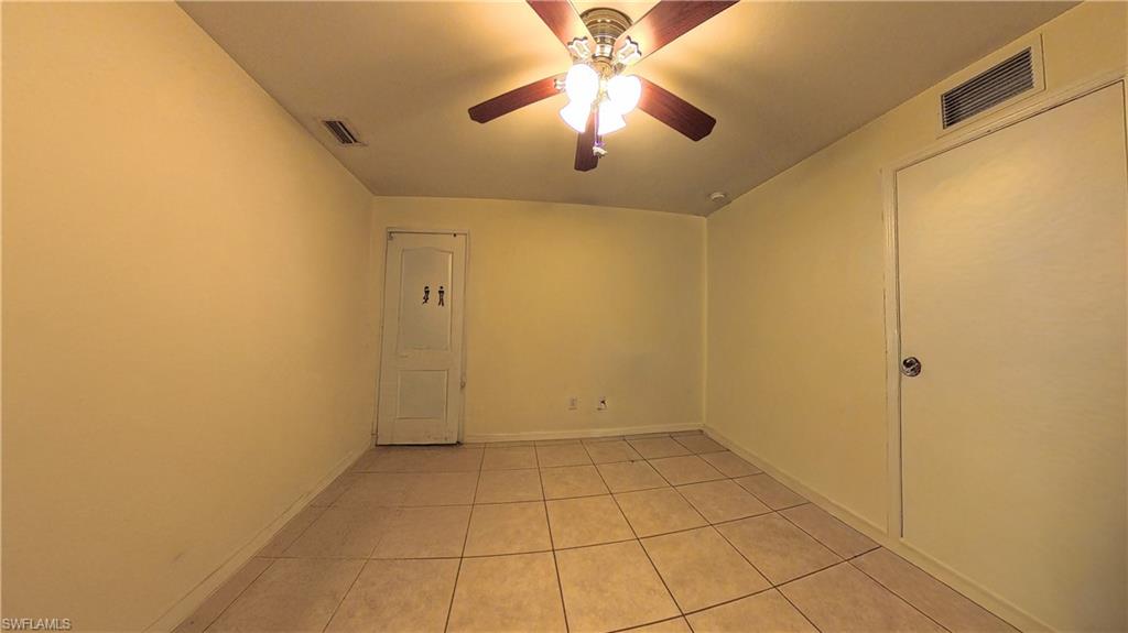 Spare room featuring light tile patterned floors and ceiling fan