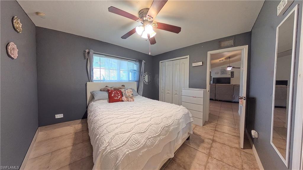 Bedroom with a ceiling fan, a closet, and light tile patterned floors
