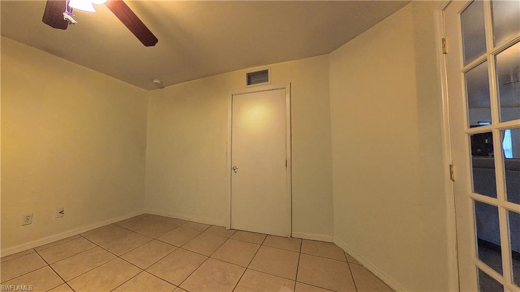 Empty room with light tile patterned floors and ceiling fan