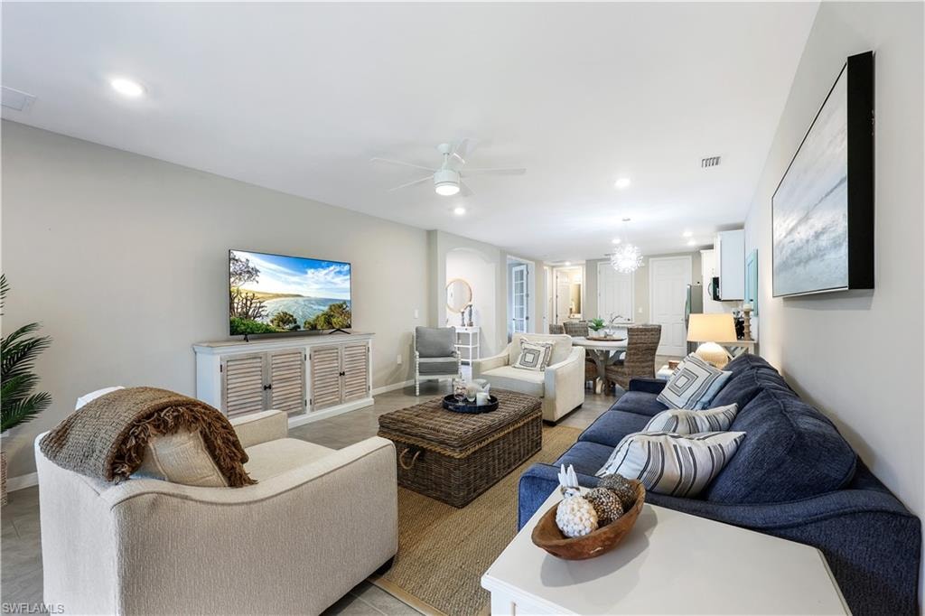 Living room with a ceiling fan, recessed lighting, and a chandelier