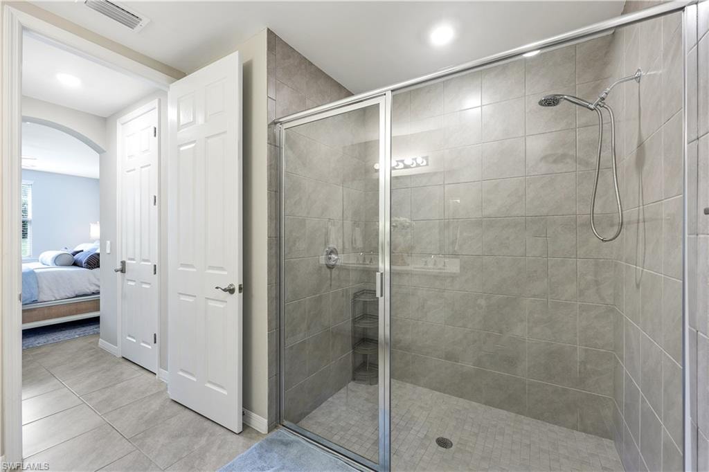 Full bath with connected bathroom, a shower stall, light tile patterned floors, and recessed lighting