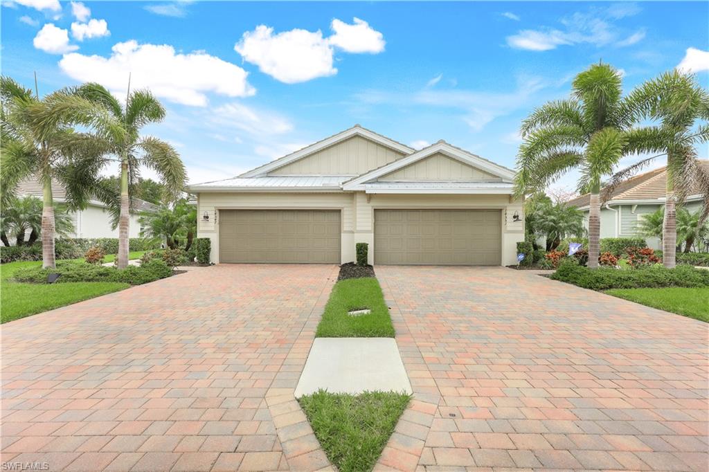 Ranch-style home with board and batten siding and decorative driveway