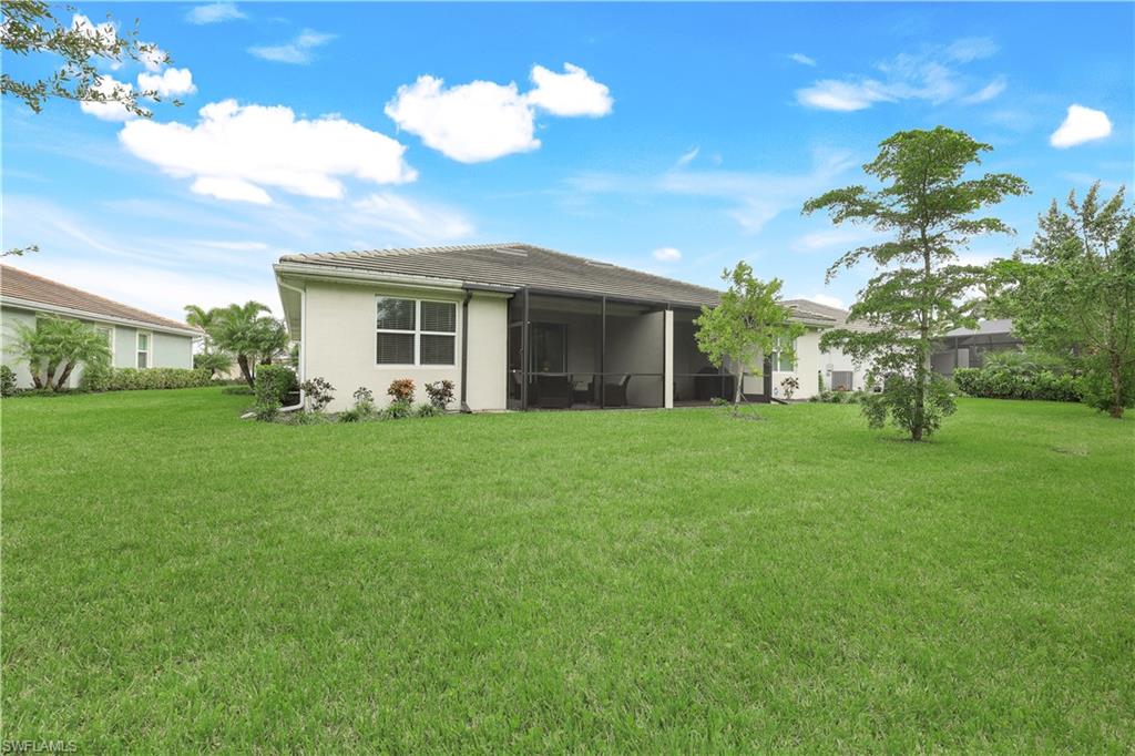Rear view of house with a lawn and a sunroom