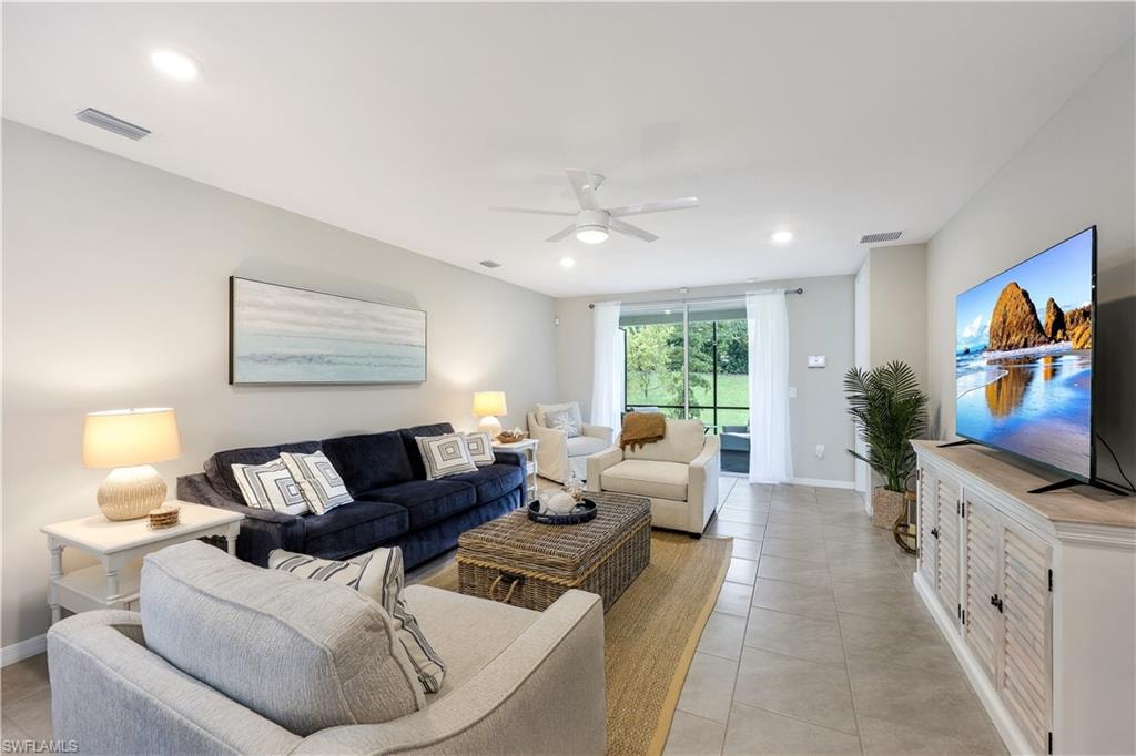 Living room with a ceiling fan, light tile patterned floors, and recessed lighting