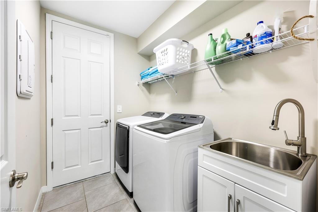 Washroom featuring light tile patterned floors, independent washer and dryer, and electric panel