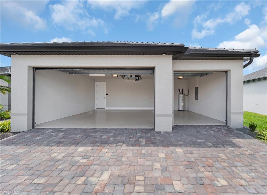 Garage featuring driveway and electric water heater