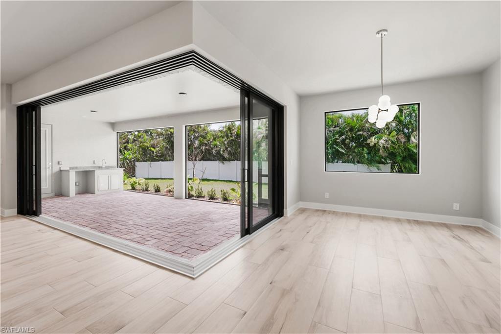 Unfurnished living room with a healthy amount of sunlight, wood finished floors, and baseboards