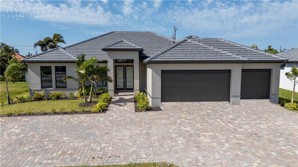 Ranch-style house with french doors, an attached garage, driveway, and stucco siding