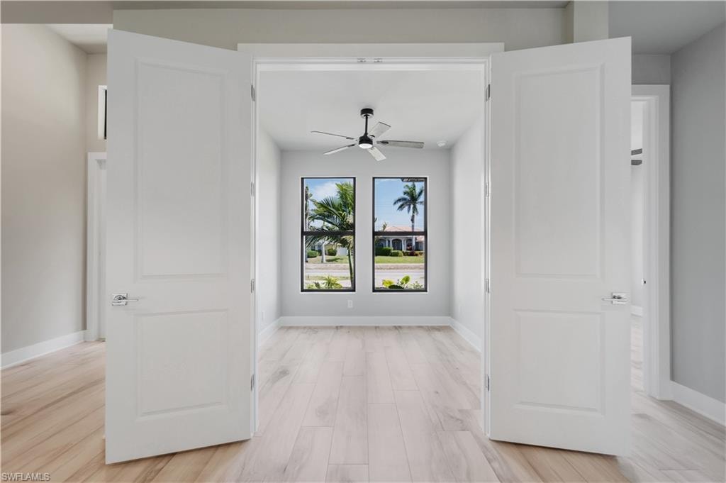 Hallway with light wood-style floors and baseboards