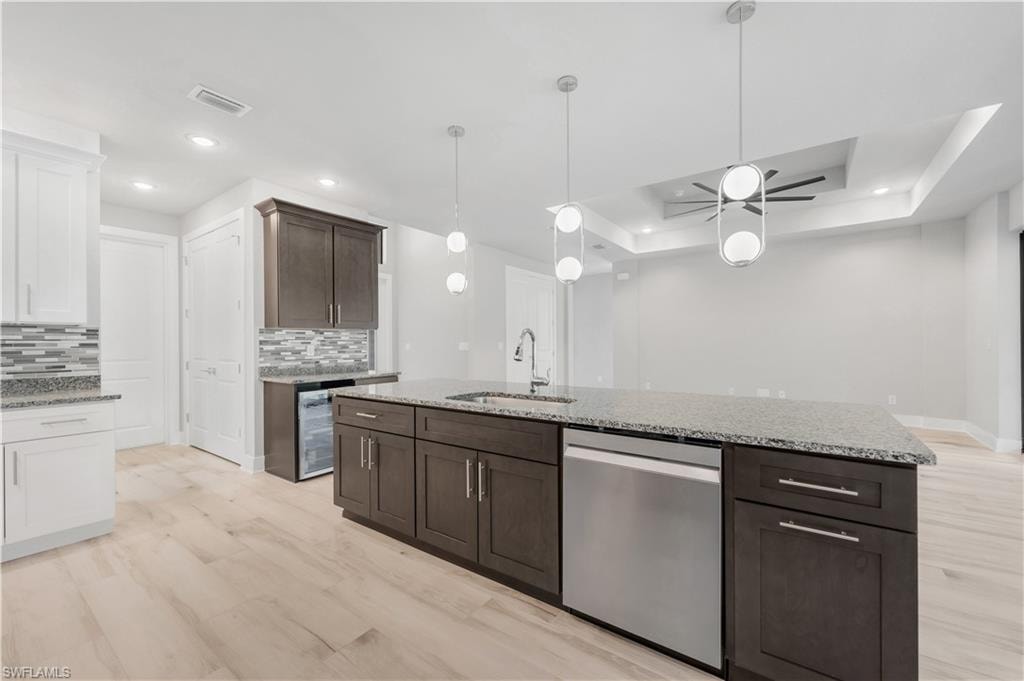 Kitchen featuring a sink, visible vents, stainless steel dishwasher, and backsplash