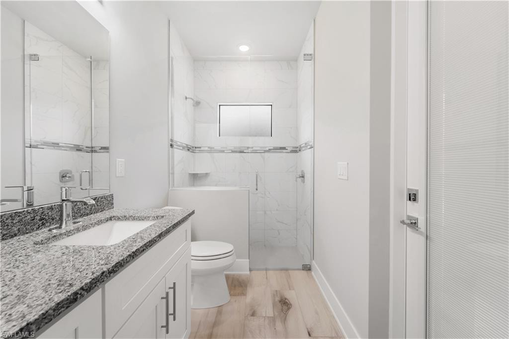 Pool Bath toilet, vanity, baseboards, and a marble finish shower