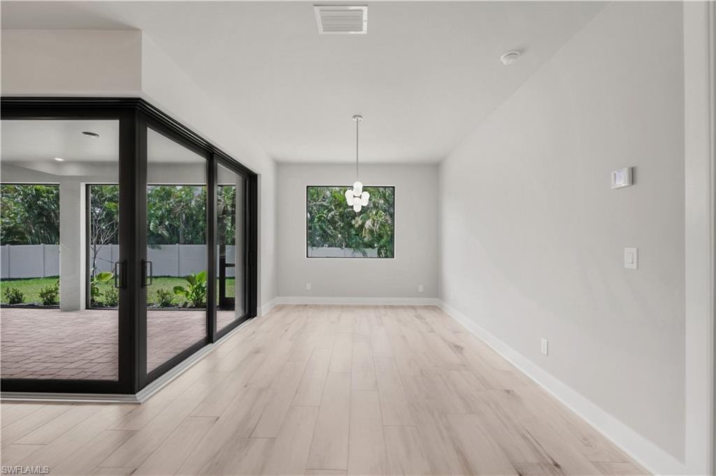 Unfurnished dining area with light wood-type flooring, visible vents, and baseboards