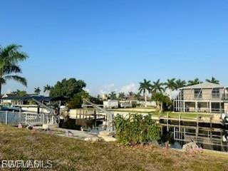 Dock area featuring a water view and a yard
