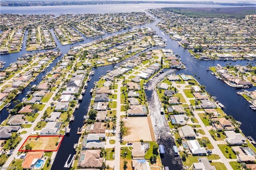 Aerial view of residential area with a large body of water and property boundaries highlighted