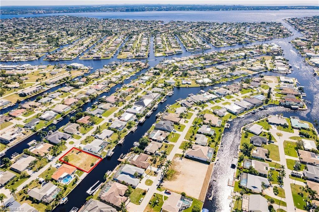 Aerial perspective of suburban area with a large body of water and property parcel outlined