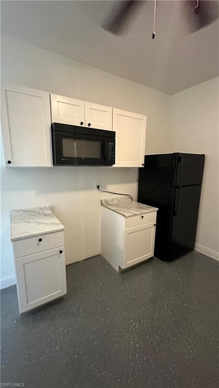 Kitchen with black appliances, white cabinetry, and light countertops