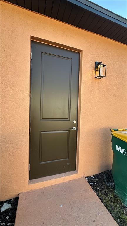 Property entrance featuring stucco siding