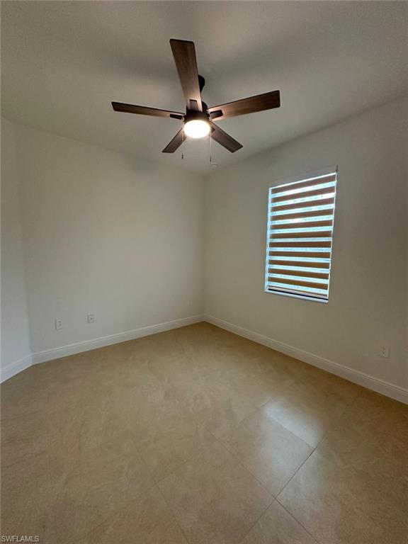Spare room with baseboards and a ceiling fan