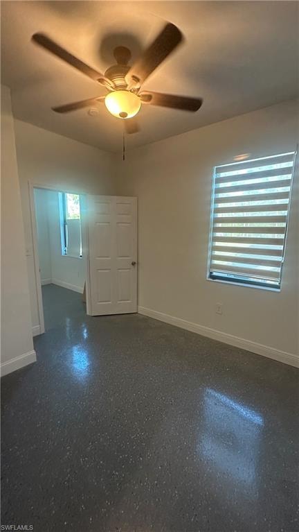 Spare room with a ceiling fan and baseboards