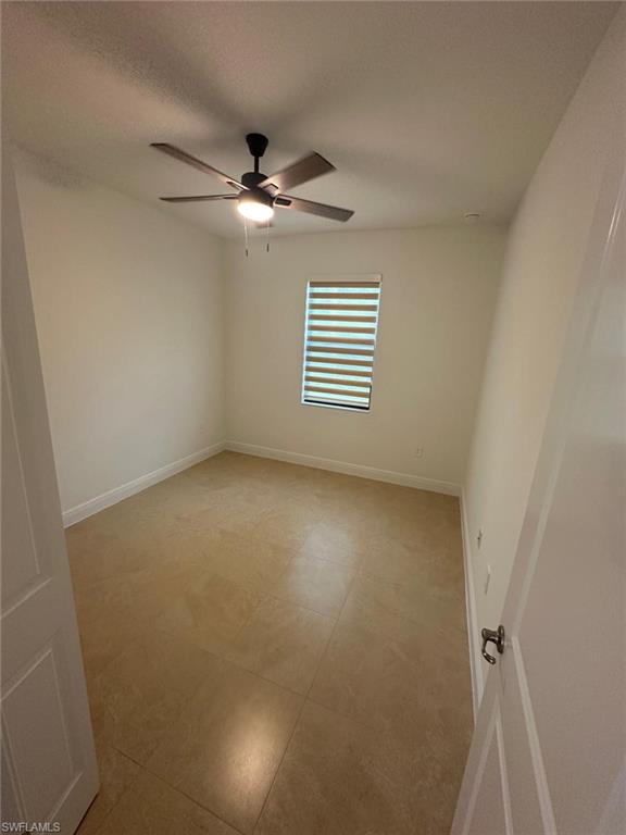 Empty room featuring a textured ceiling and ceiling fan