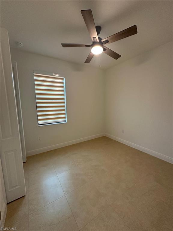 Unfurnished room featuring light tile patterned floors and a ceiling fan