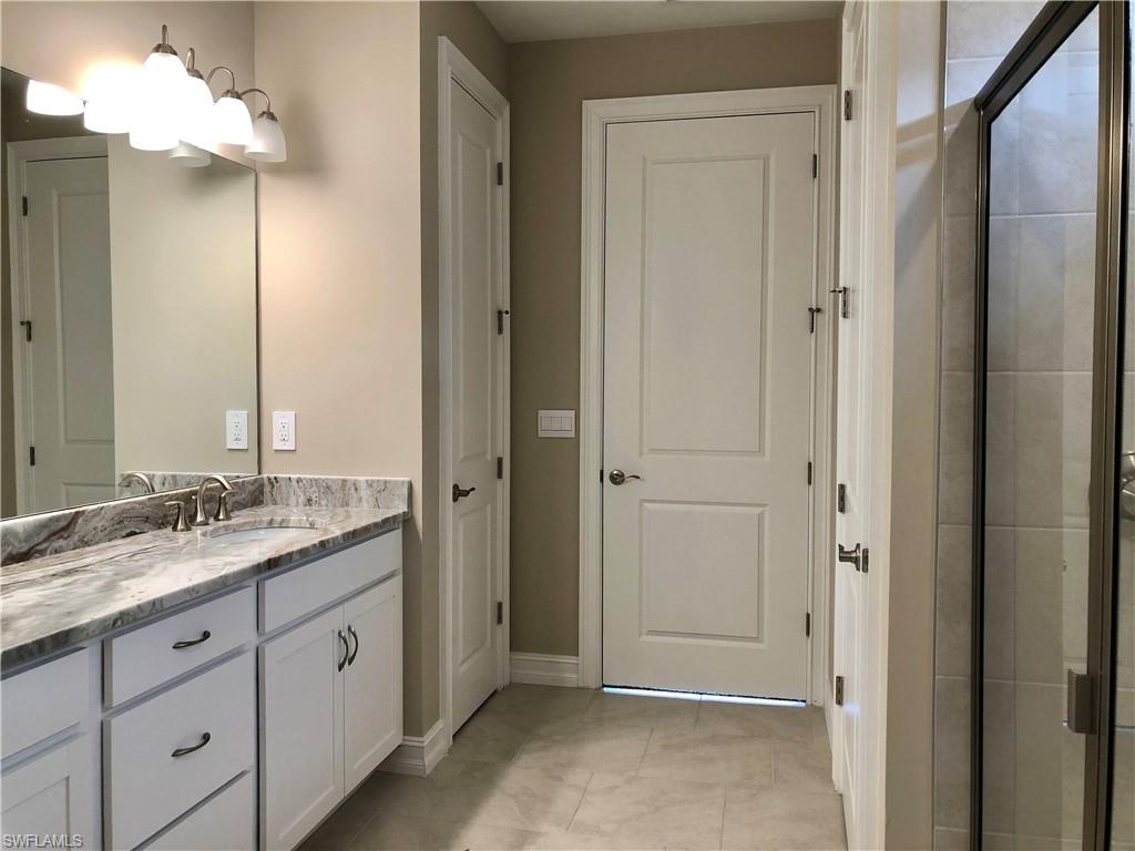 Kitchen with stainless steel appliances, a kitchen island with sink, a breakfast bar area, white cabinetry, and recessed lighting