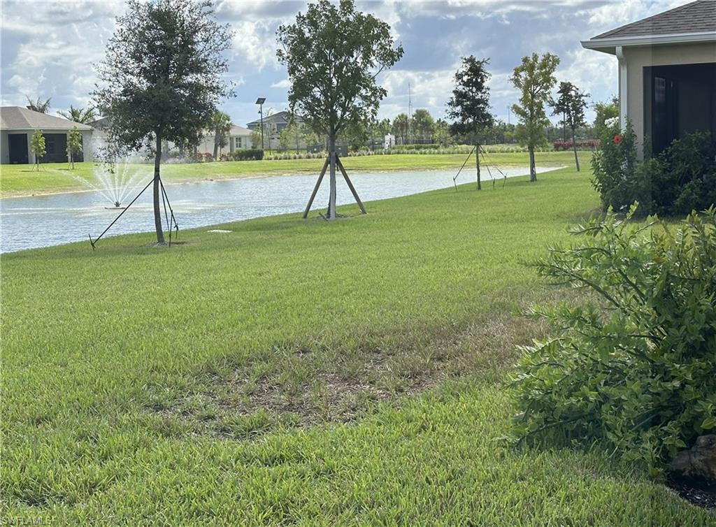 View of green lawn featuring a water view