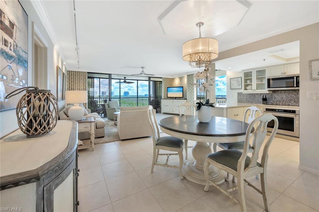 Dining space featuring light tile patterned floors, crown molding, a chandelier, and floor to ceiling windows