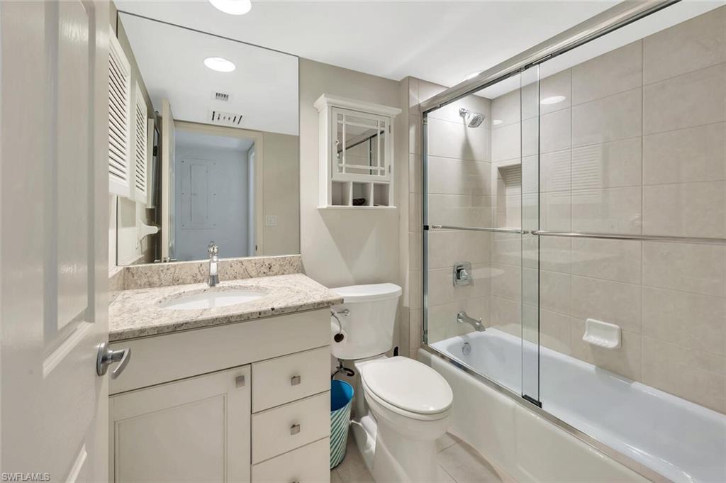 Bathroom with vanity, combined bath / shower with glass door, and recessed lighting