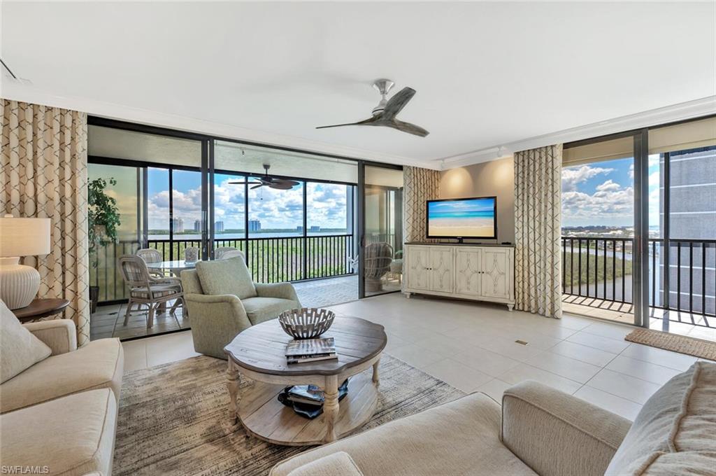 Tiled living area with a wall of windows and ceiling fan
