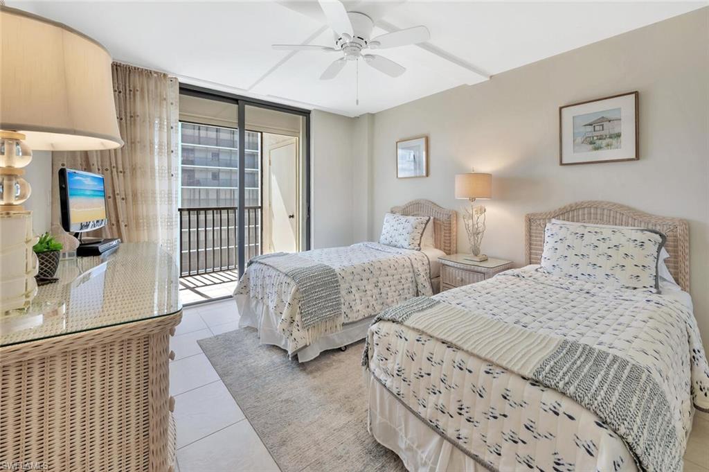 Tiled bedroom with access to outside, expansive windows, and a ceiling fan