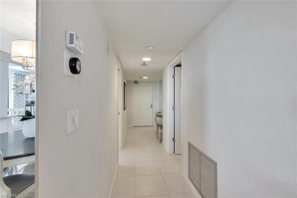 Hallway featuring light tile patterned flooring and baseboards