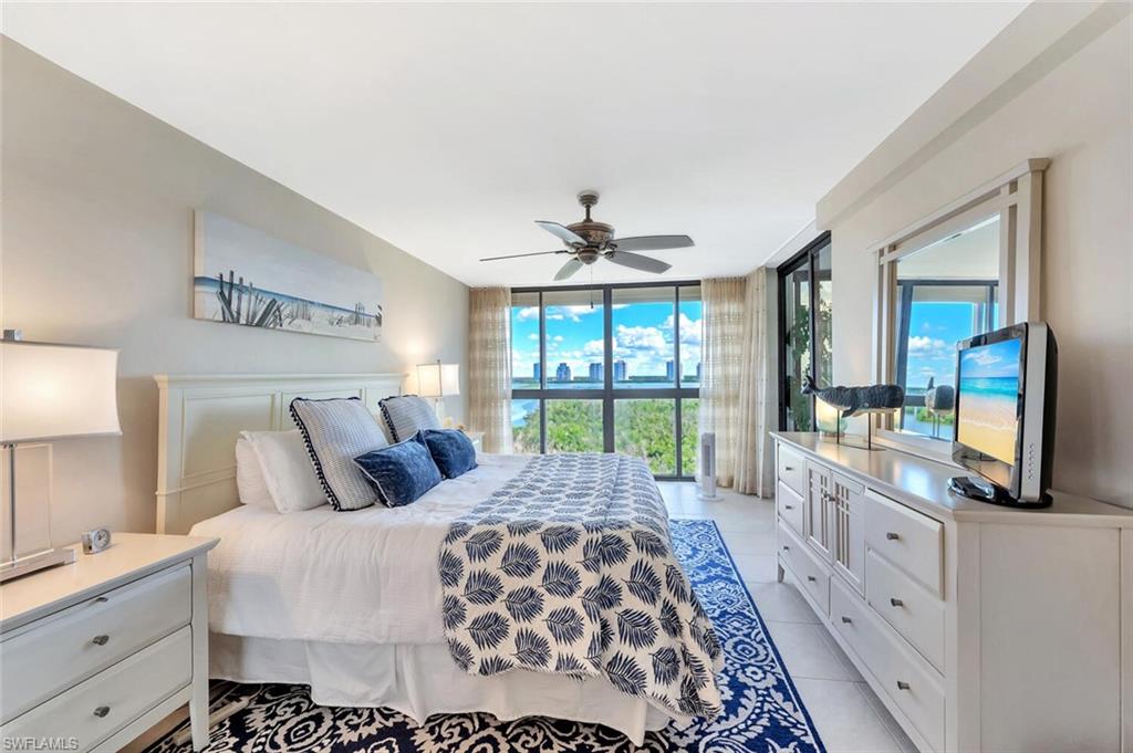 Bedroom featuring a wall of windows, light tile patterned floors, and ceiling fan