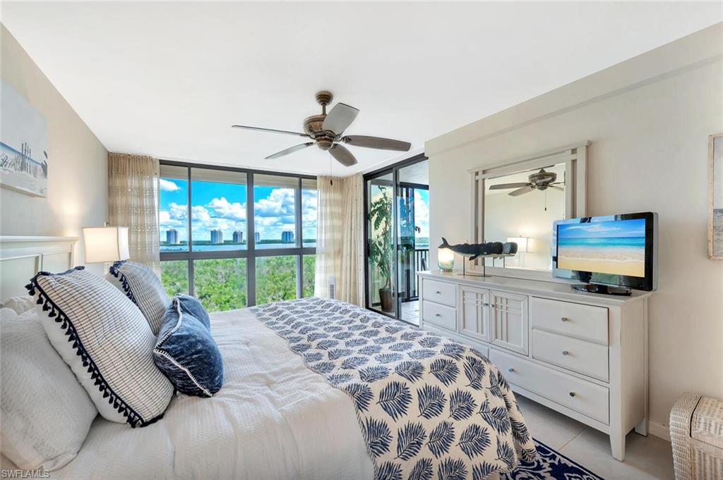 Bedroom featuring access to outside, floor to ceiling windows, and light tile patterned floors