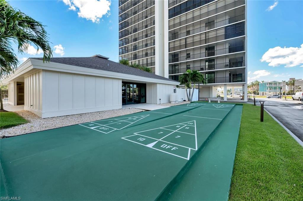 Surrounding community featuring shuffleboard and a yard